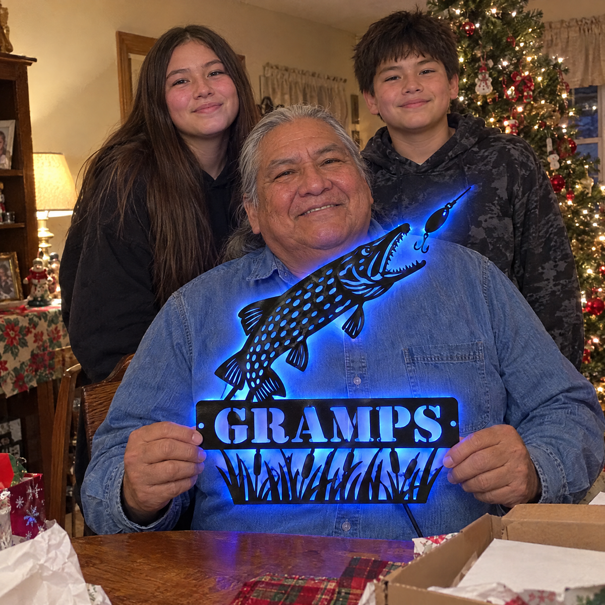 Grandkids with grandpa holding GRAMPS pike LED sign at Christmas