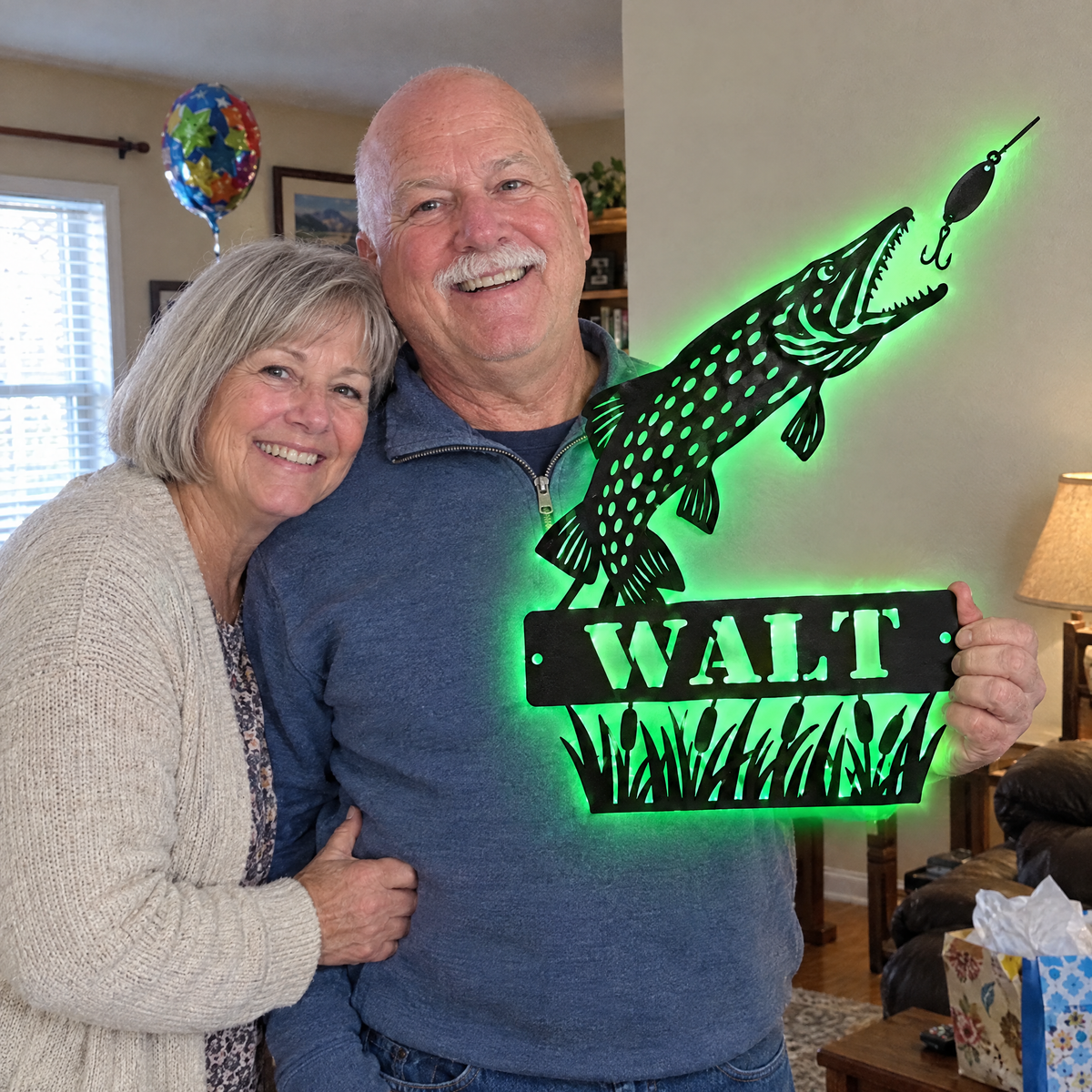 Wife hugs retiring husband holding lit WALT pike sign
