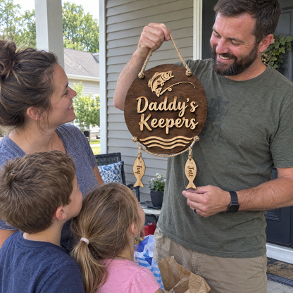 Dad holds up Daddy's Keepers sign with family on the porch for Father's Day