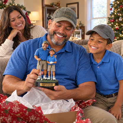 Mom watches dad unwrap the father and son golf figurine at Christmas with the son beside him