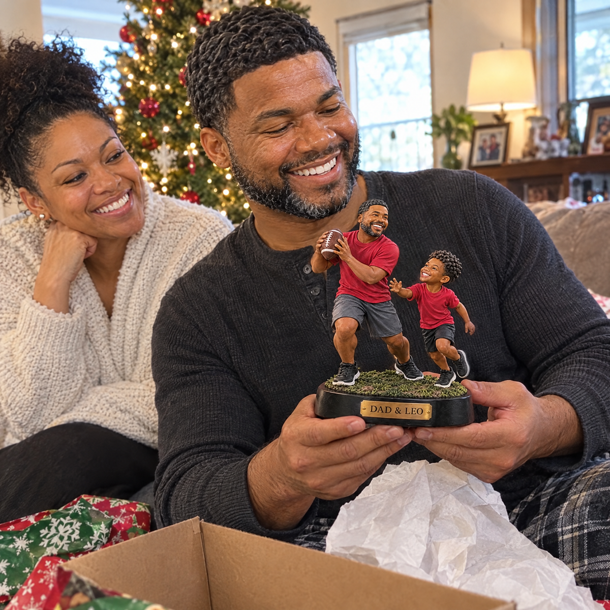 Mom watches dad unwrap the father and son football figurine at Christmas